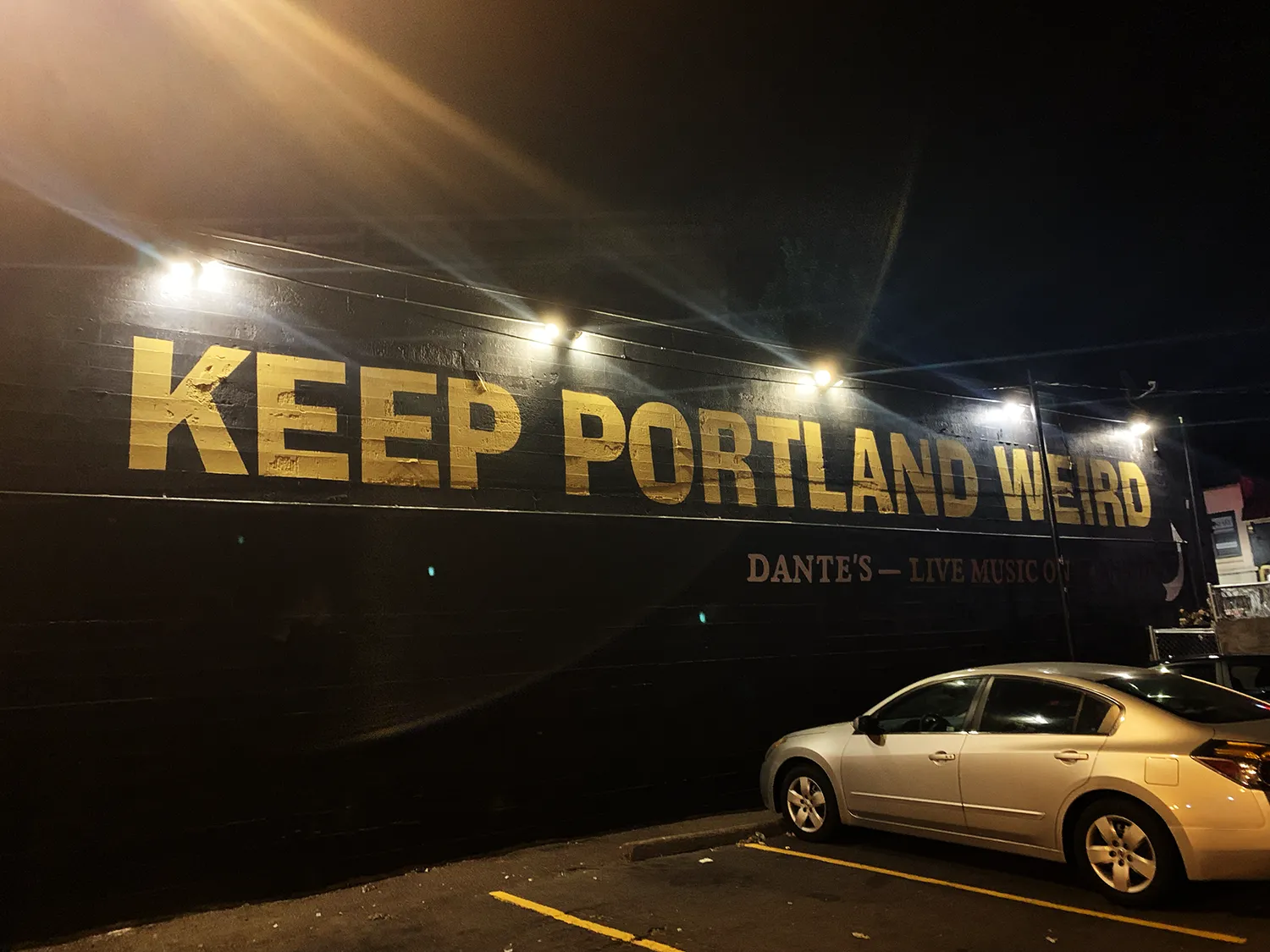 アメリカポートランドのスローガン看板前の写真。KEEP PORTLAND WEIRDと書かれている